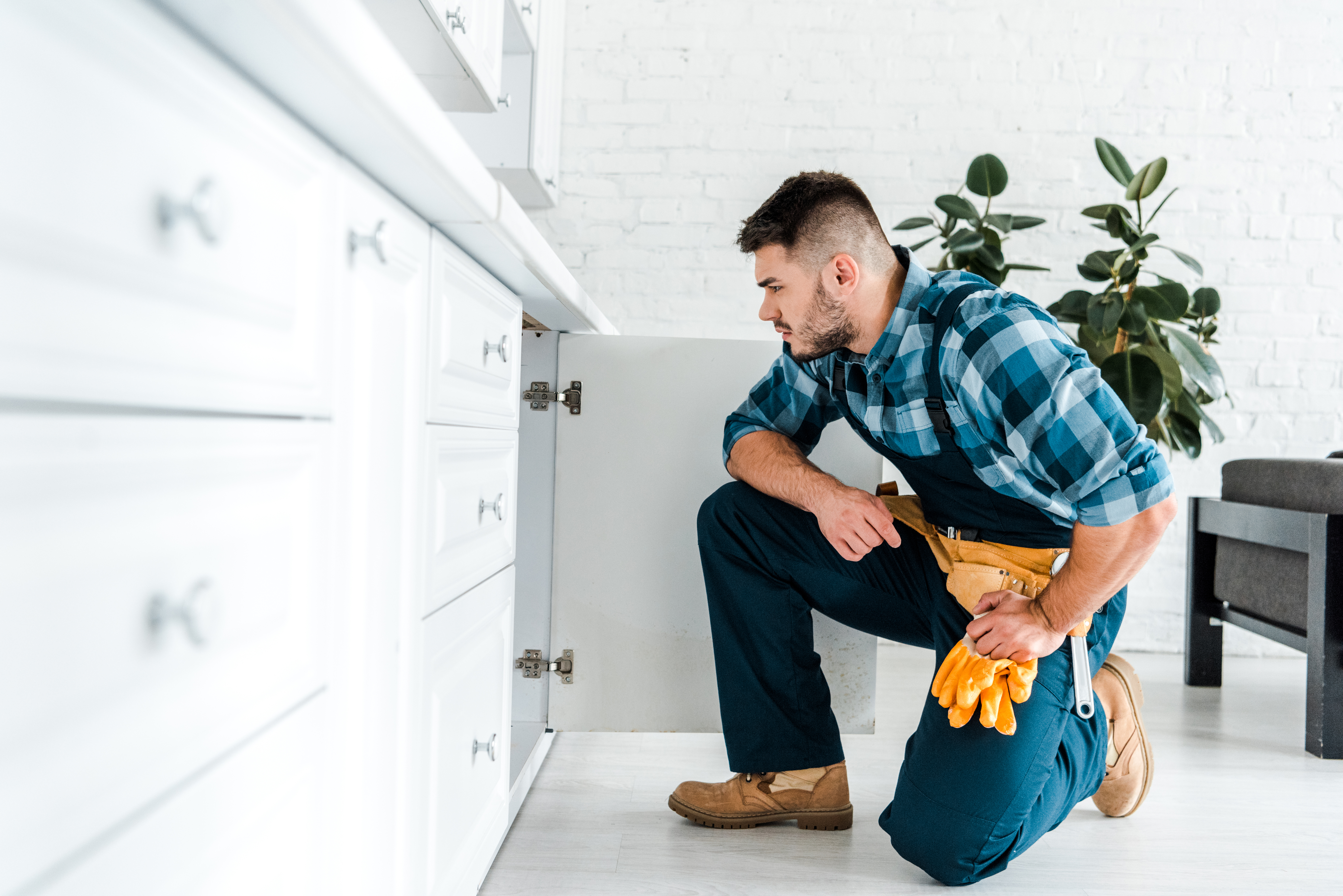 Homme réparant le placard de la cuisine
