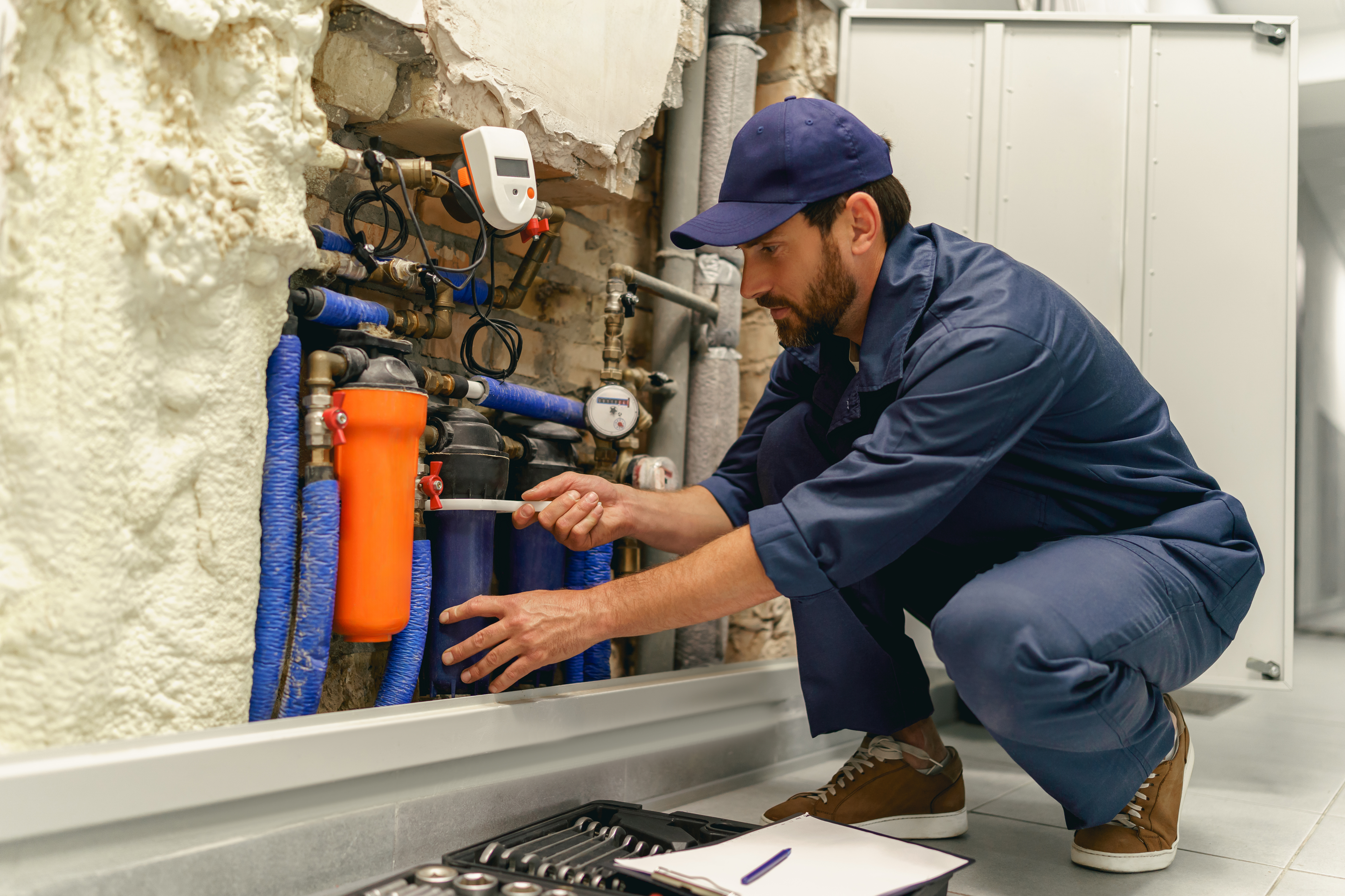 Technicien vérifiant l'équipement de plomberie industrielle.